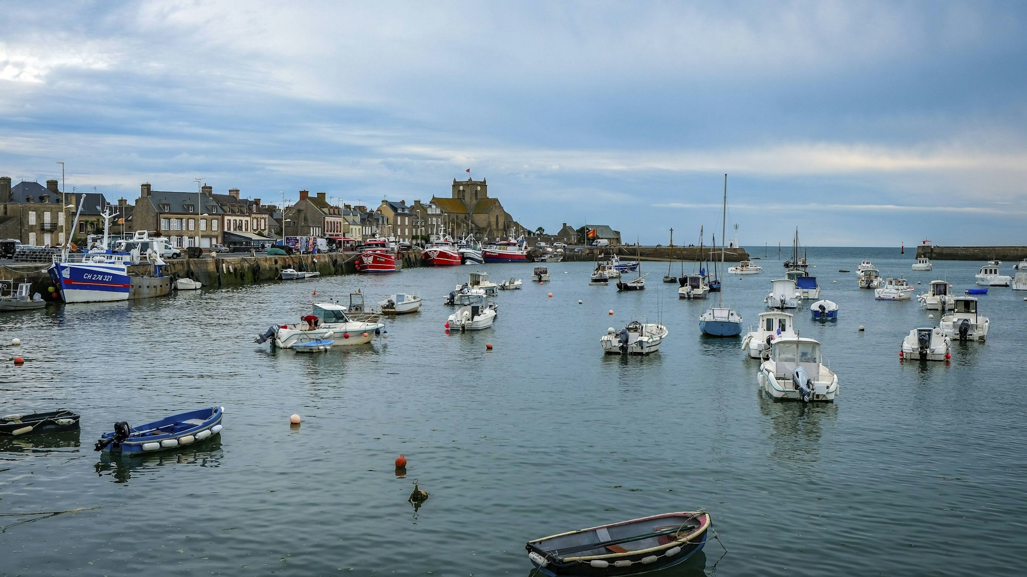 Fischerboote ankern in einem kleinen Hafen vor einer Häuserzeile
