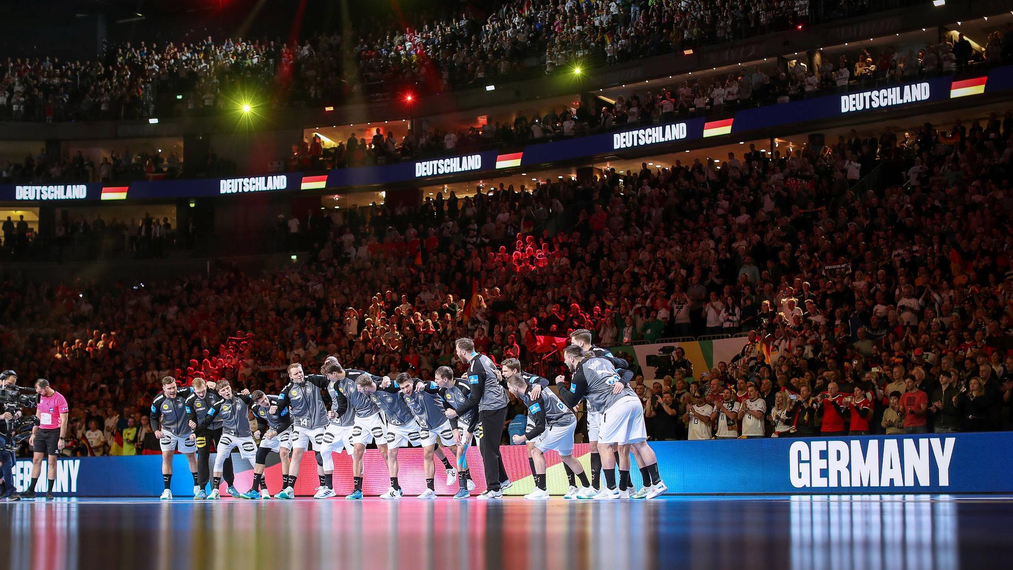 Die deutsche Handball-Nationalmannschaft steht während der Hymne auf der Platte.