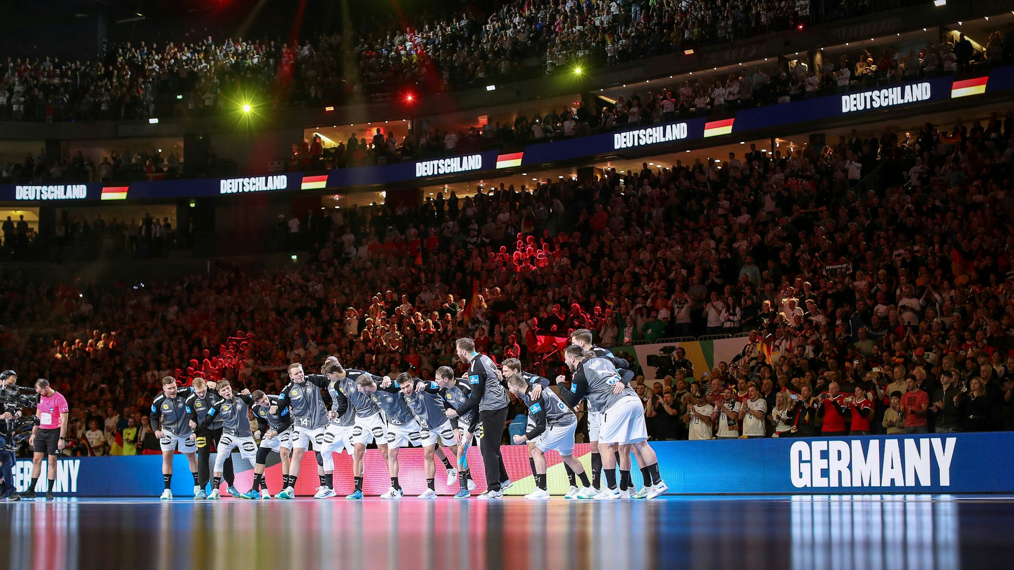 Die deutsche Handball-Nationalmannschaft steht während der Hymne auf der Platte.