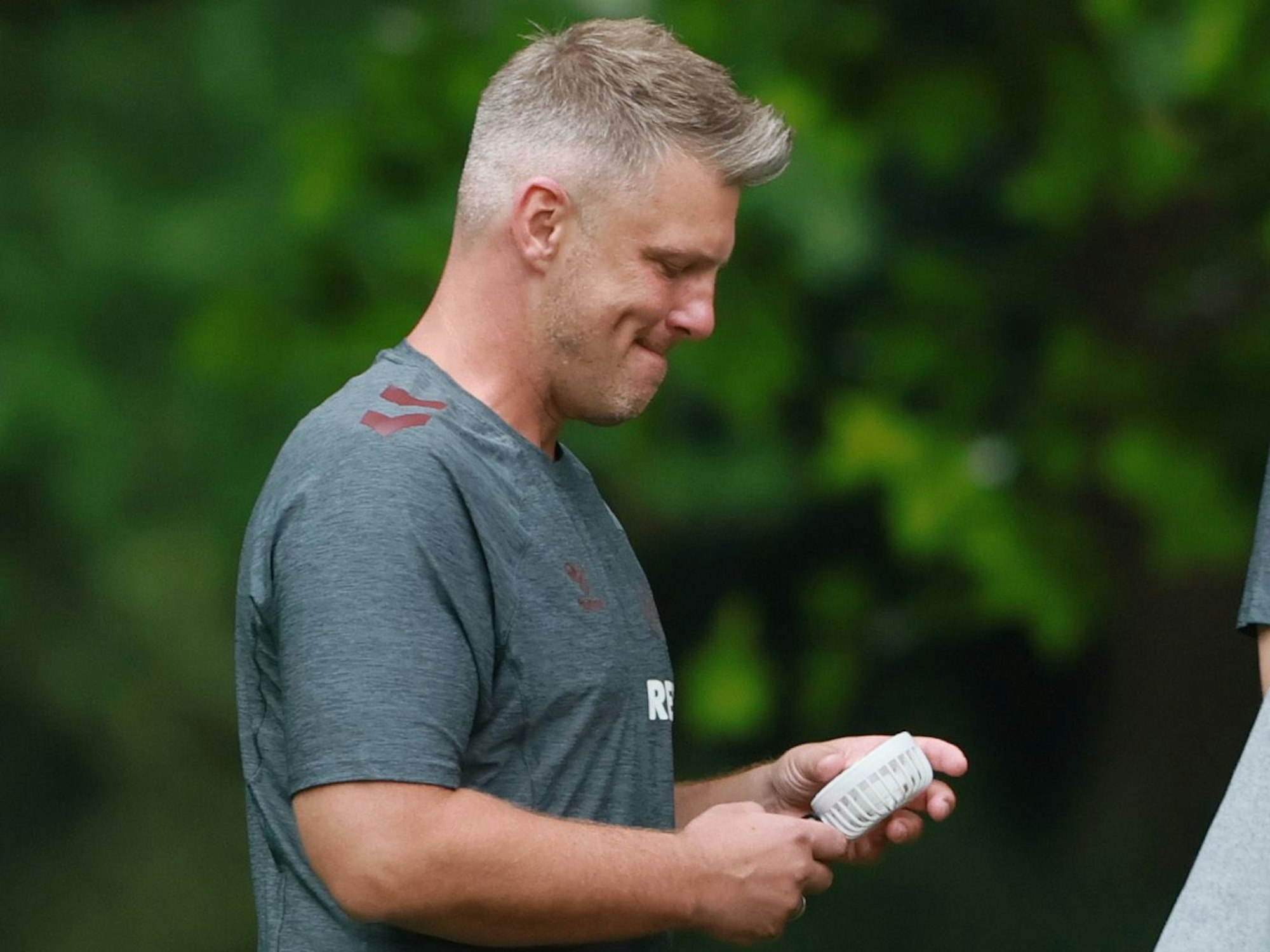 FC-Trainer Lukas Kwasniok hatte trotz Regen einen kleinen Ventilator beim Fotoshooting für das FC-Mannschaftsfoto dabei.