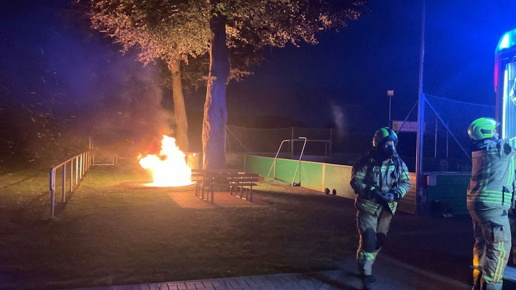 Ein brennender Baumstamm auf dem Sportplatz in Veen.