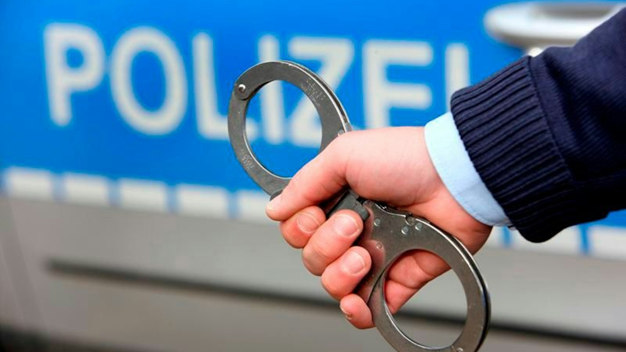 Zwei Männer werden von Polizisten und Polizistinnen festgenommen.