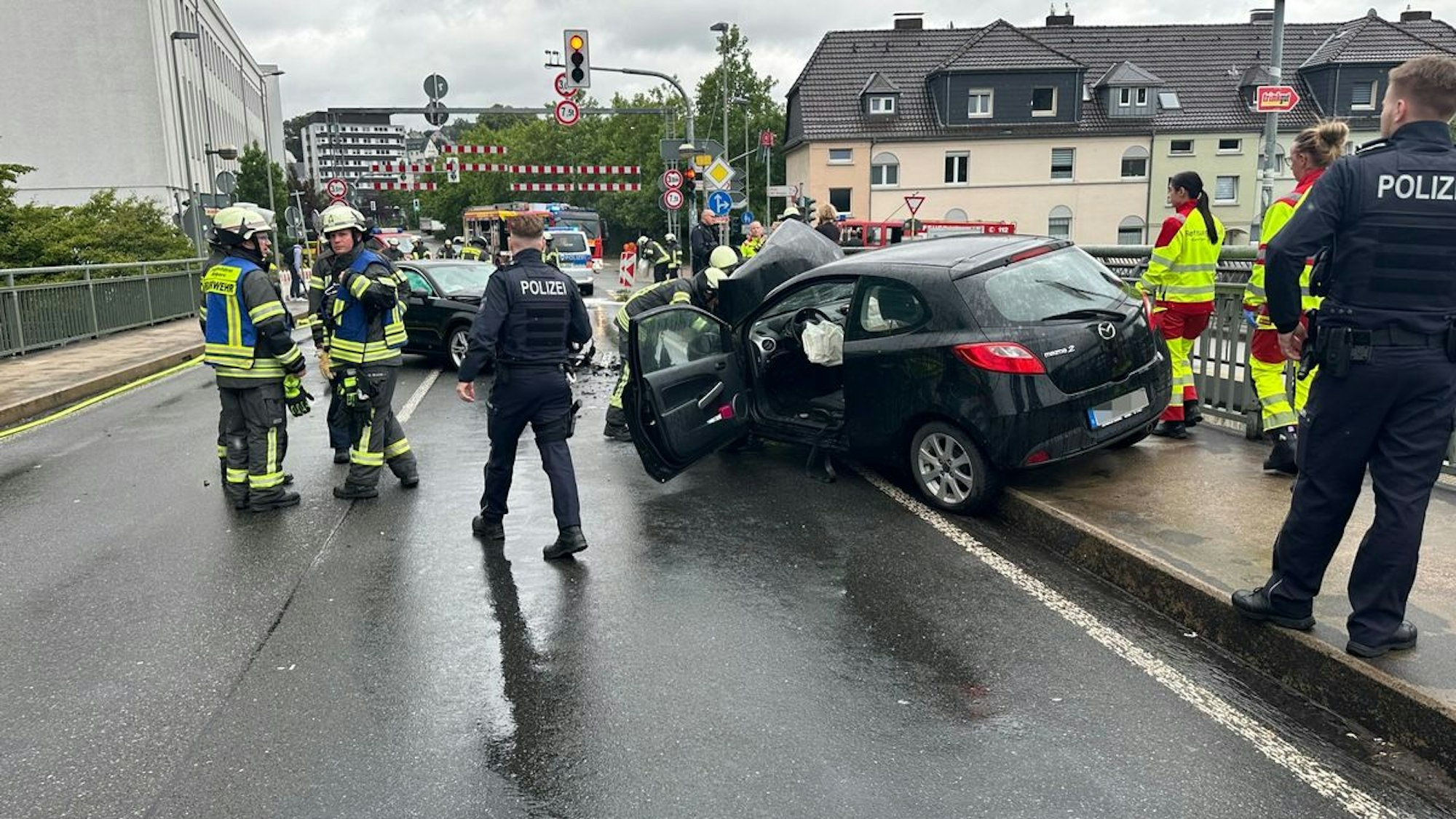 Zwei frontal kollidierte Autos auf der Ruhrbrücke in Wetter, ein Feuerwehrmann ist im Vordergrund zu sehen.