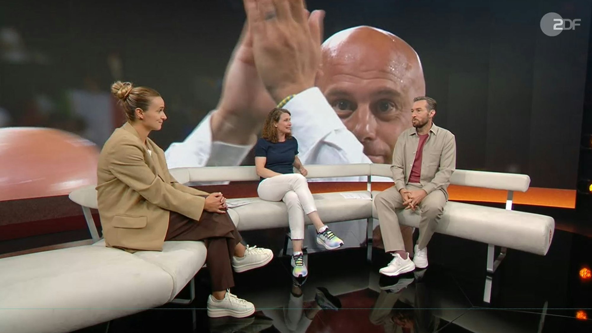 Sven Voss, Kathrin Lehmann und Lina Magull sitzen im TV-Studio. Auf einem Screen im Hintergrund ist Italien-Trainer Andrea Soncin zu sehen.