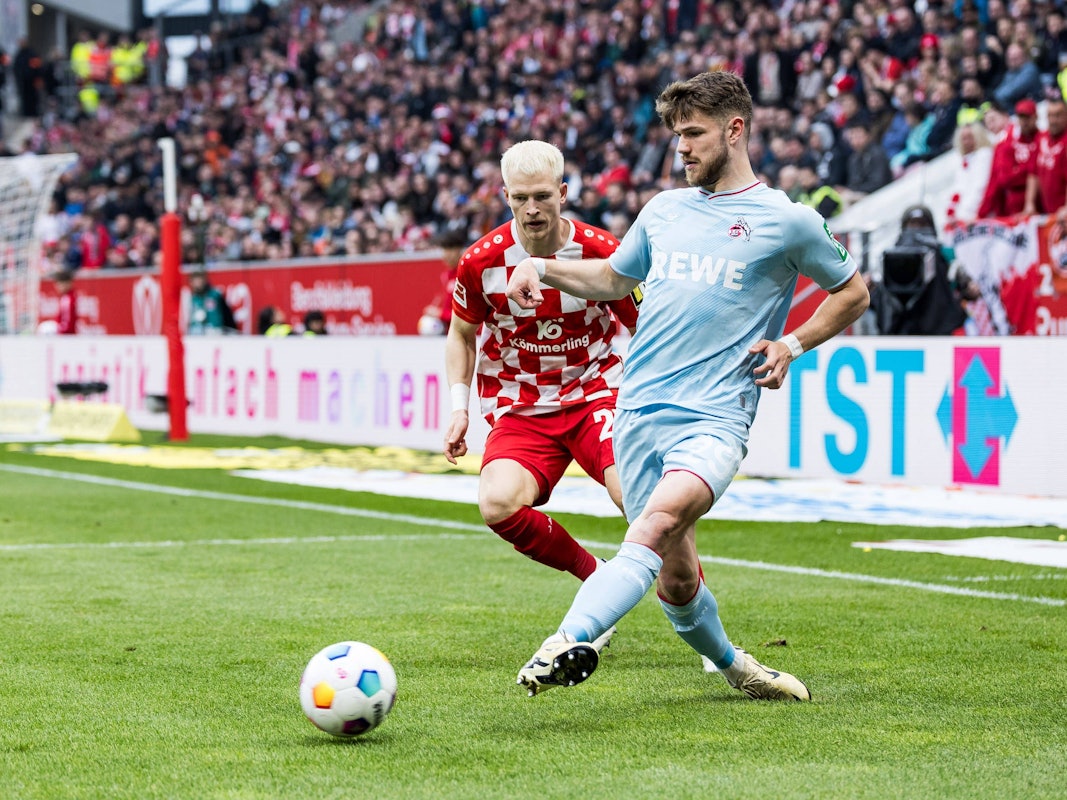 Kölns Jan Thielmann passt den Ball, Mainz-Profi Andreas Hanche-Olsen steht daneben.