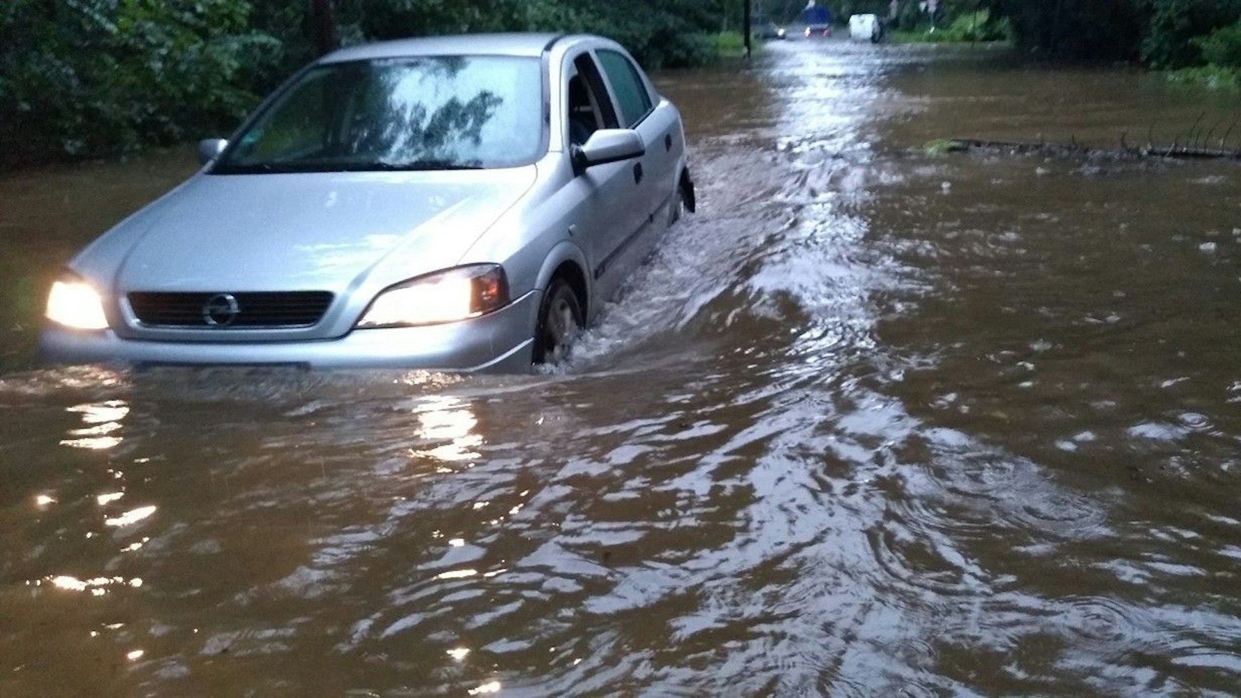 Ein Auto steckt im Hochwasser in Dünnwald fest.