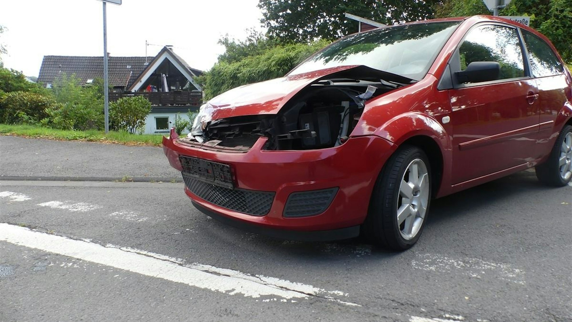 Zwei Autos stehen nach einem Unfall beschädigt auf einer Kreuzung.