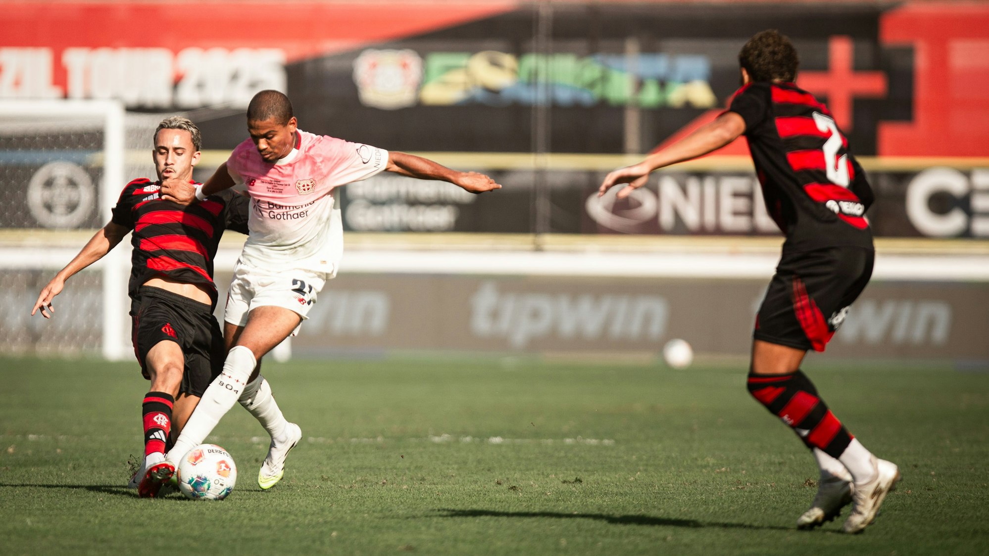 Bayer-Profi Amine Adli (M.), Matheus Gonçalves (l.) und Iago (r.) kämpfen um den Ball.