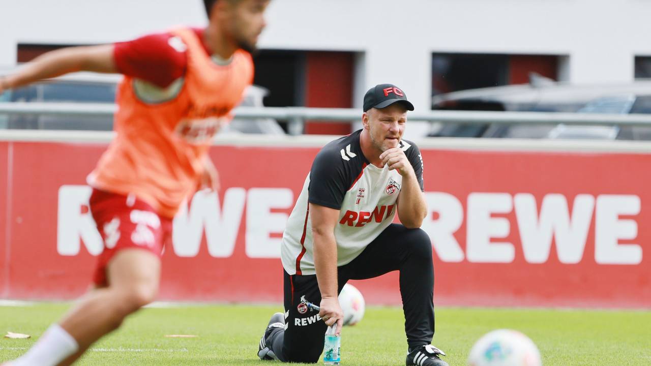 Lukas Kwasniok hockt mit einem Knie auf dem Trainingsplatz des 1. FC Köln.