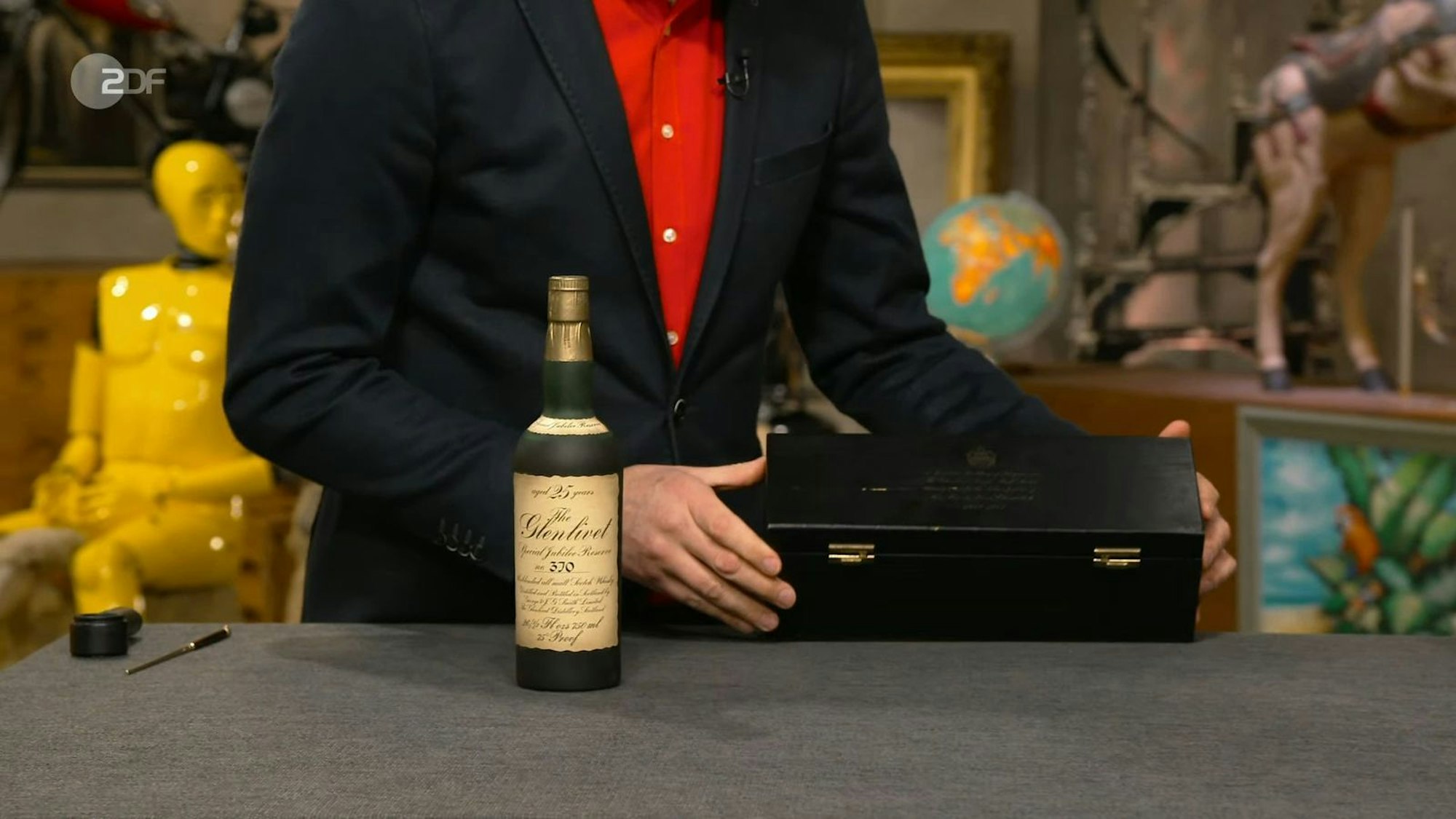 Die Flasche mit 25 Jahre altem Single Malt Whiskey aus dem Jahr 1977 war dem Krönungsjubiläum von Elizabeth II. gewidmet und 900 bis 1.000 Euro wert. Walter Lehnertz machte mit 600 Euro das höchste Gebot, doch die Verkäuferin lehnte ab und nahm die Flasche wieder mit.
(Bild: ZDF)