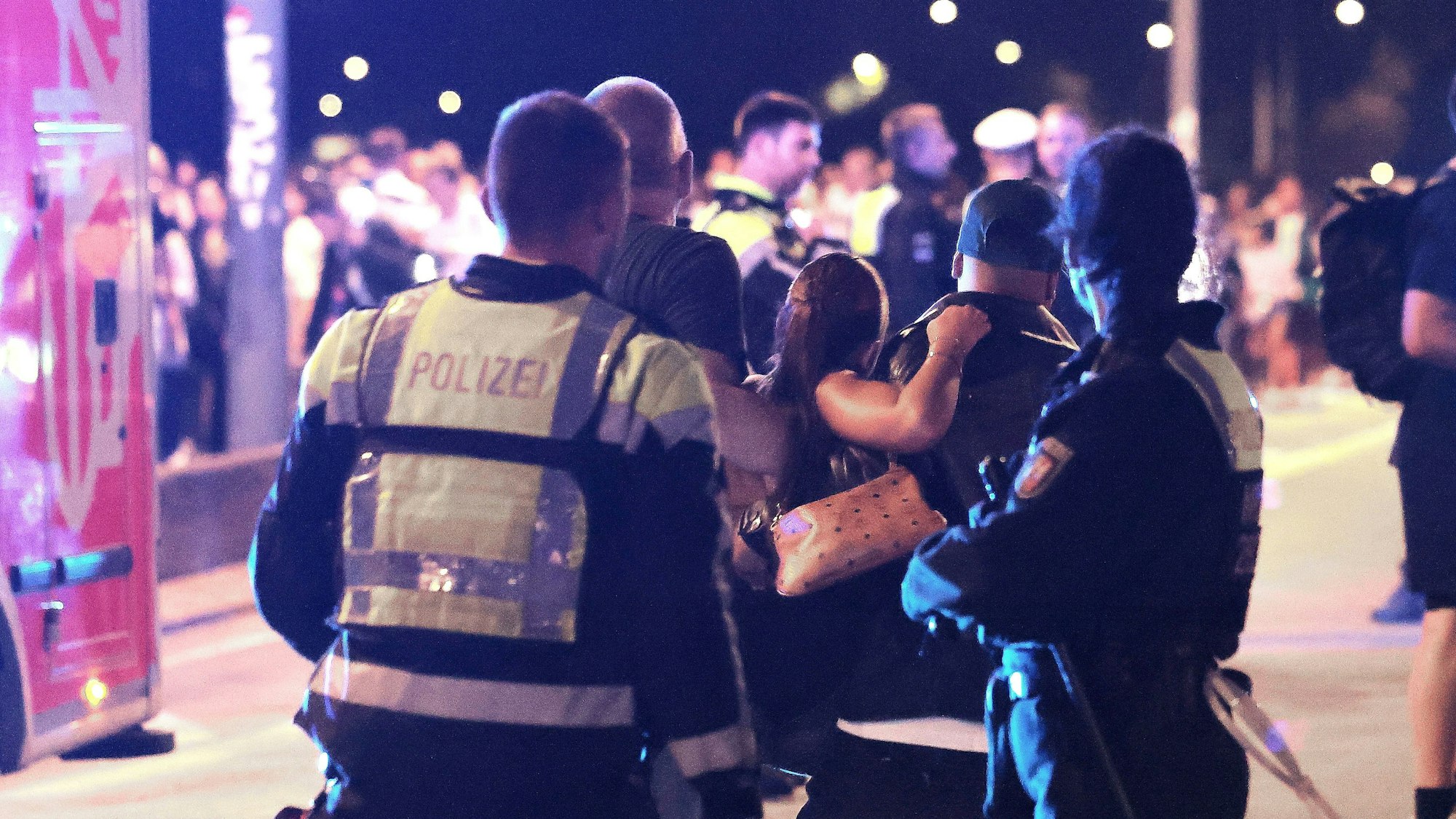 Ersthelfer und Polizisten tragen eine Verletze zu den Sanitätern.