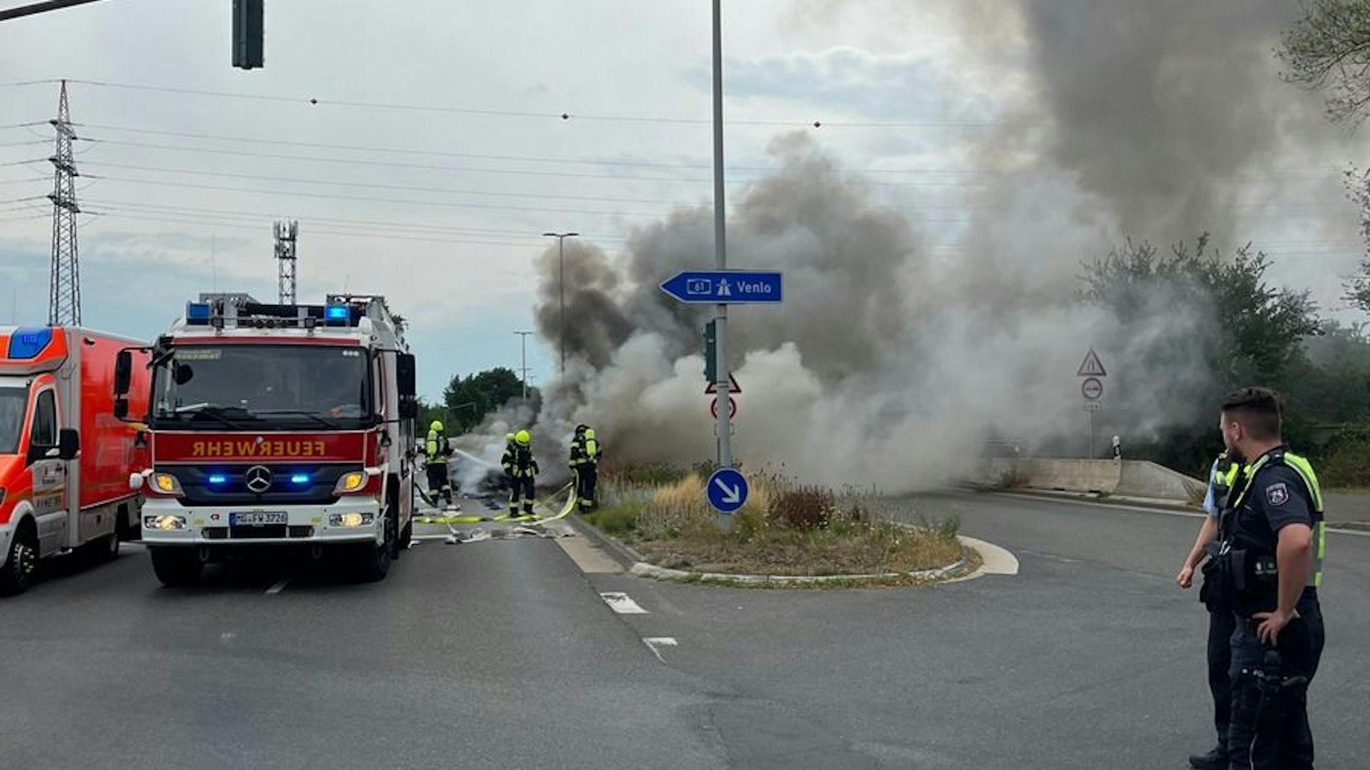 Ein völlig ausgebrannter BMW steht auf einer Straße.