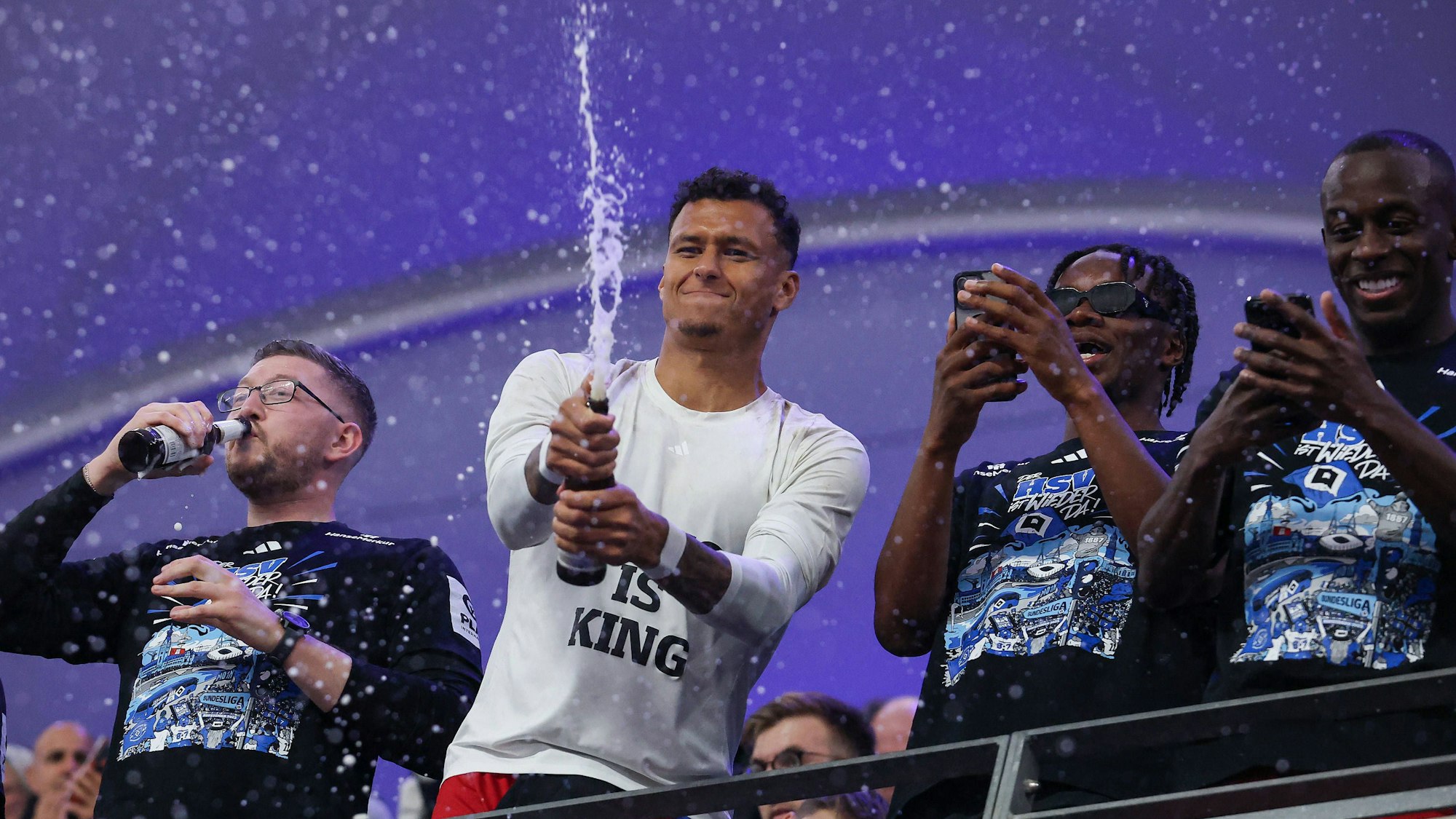 Davie Selke spritzt bei der Aufstiegsfeier Bier in Richtung Fans.