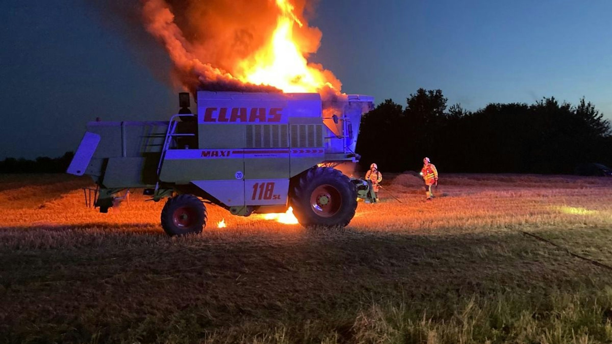 Ein brennender Mähdrescher auf einem Feld in Grevenbroich.