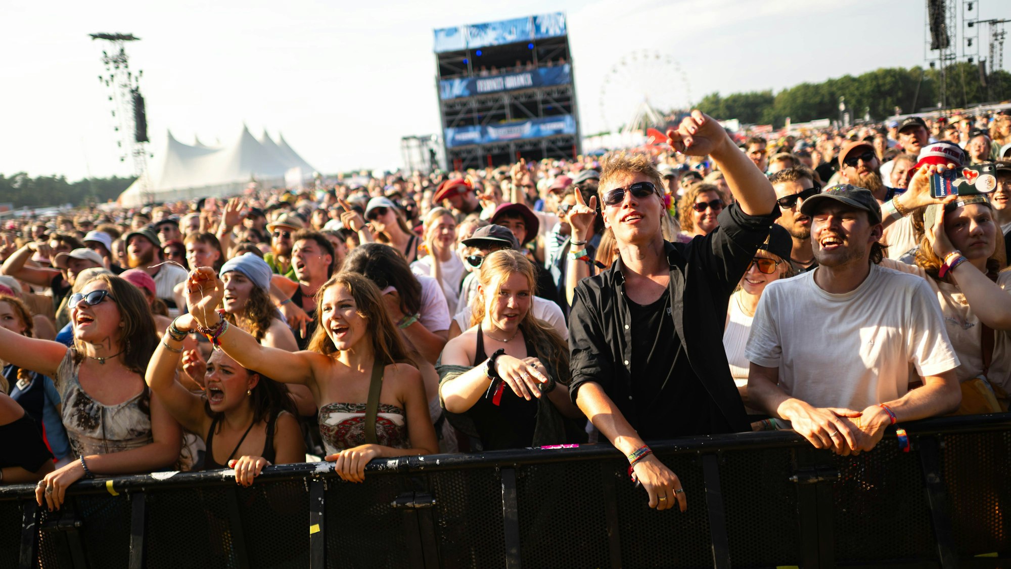 Eine Menschenmasse feiert auf einem Open-Air-Festival.