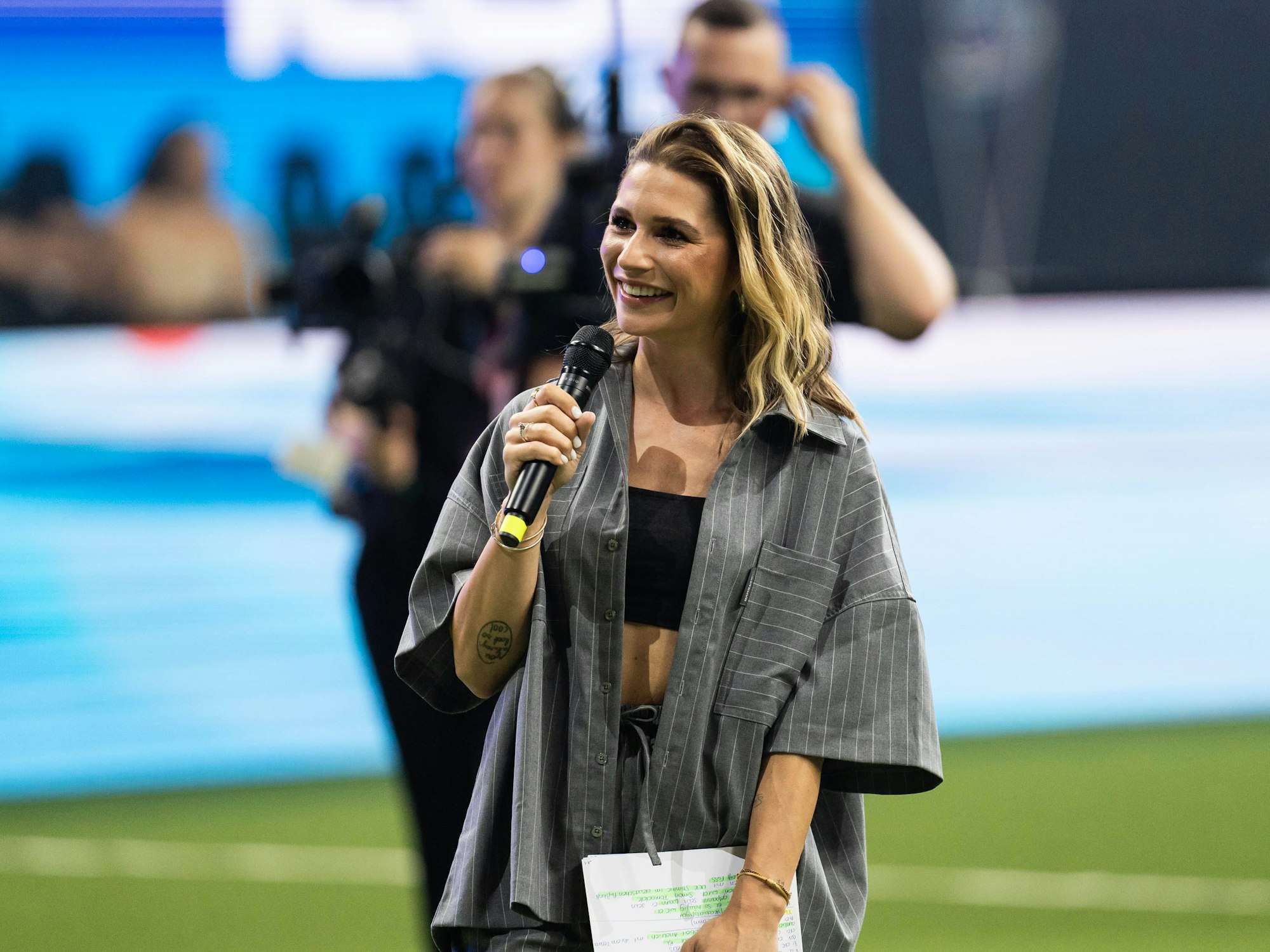 Moderatorin Jana Wosnitza hält ein Mikrofon in der Hand.