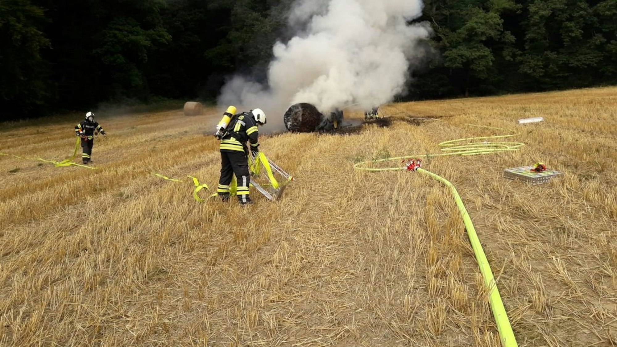 Ein ausgebrannter Traktor auf einem Feld.
