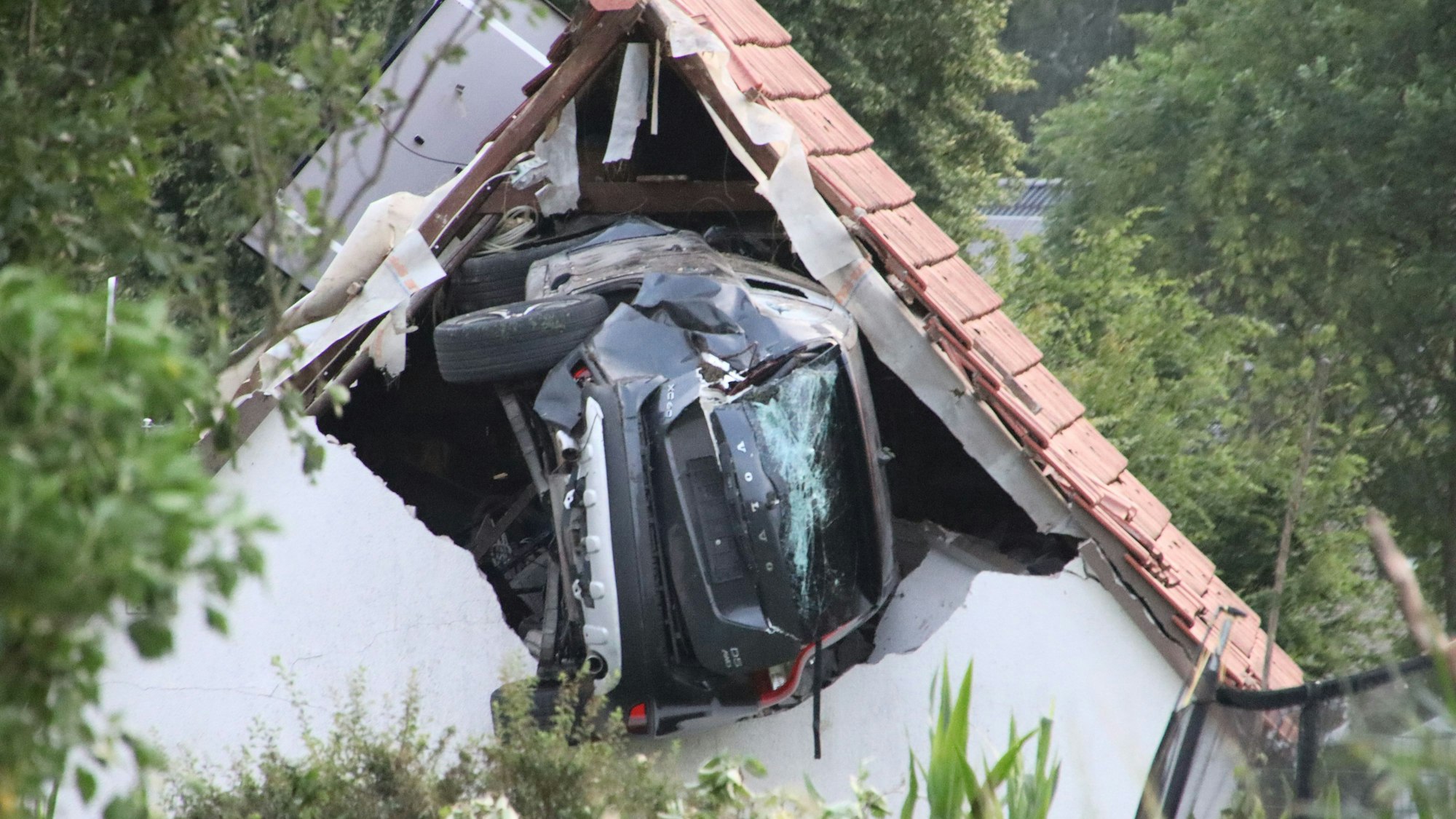 Der Volvo steckt nach dem Abflug in einer Mauer einer Scheune.