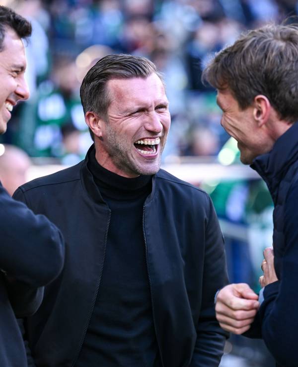Markus Krösche lacht bei einem Gespräch im Stadion.