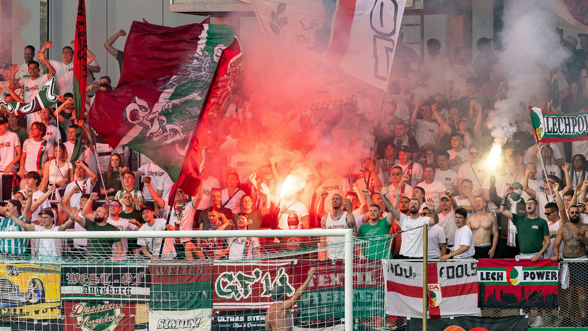 Fans des FC Augsburg zünden Pyrotechnik auf der Tribüne.