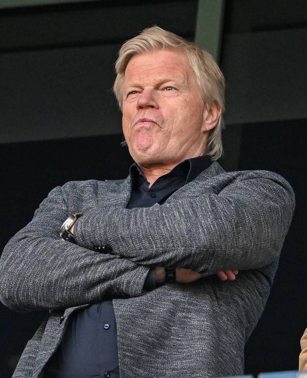 Oliver Kahn steht mit verschränkten Armen auf der Tribüne und guckt sich ein Spiel an.