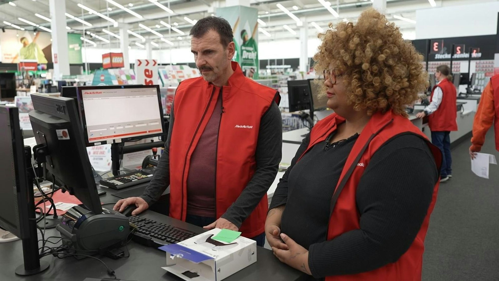 Als Probearbeiter Marco machte MediaMarktSaturn-Chef Mario Pieper völlig neue Erfahrungen. Und im Augsburger Markt an der Seite von „Ausbilderin“ Adesua leider nicht nur schöne. (Bild: RTL)