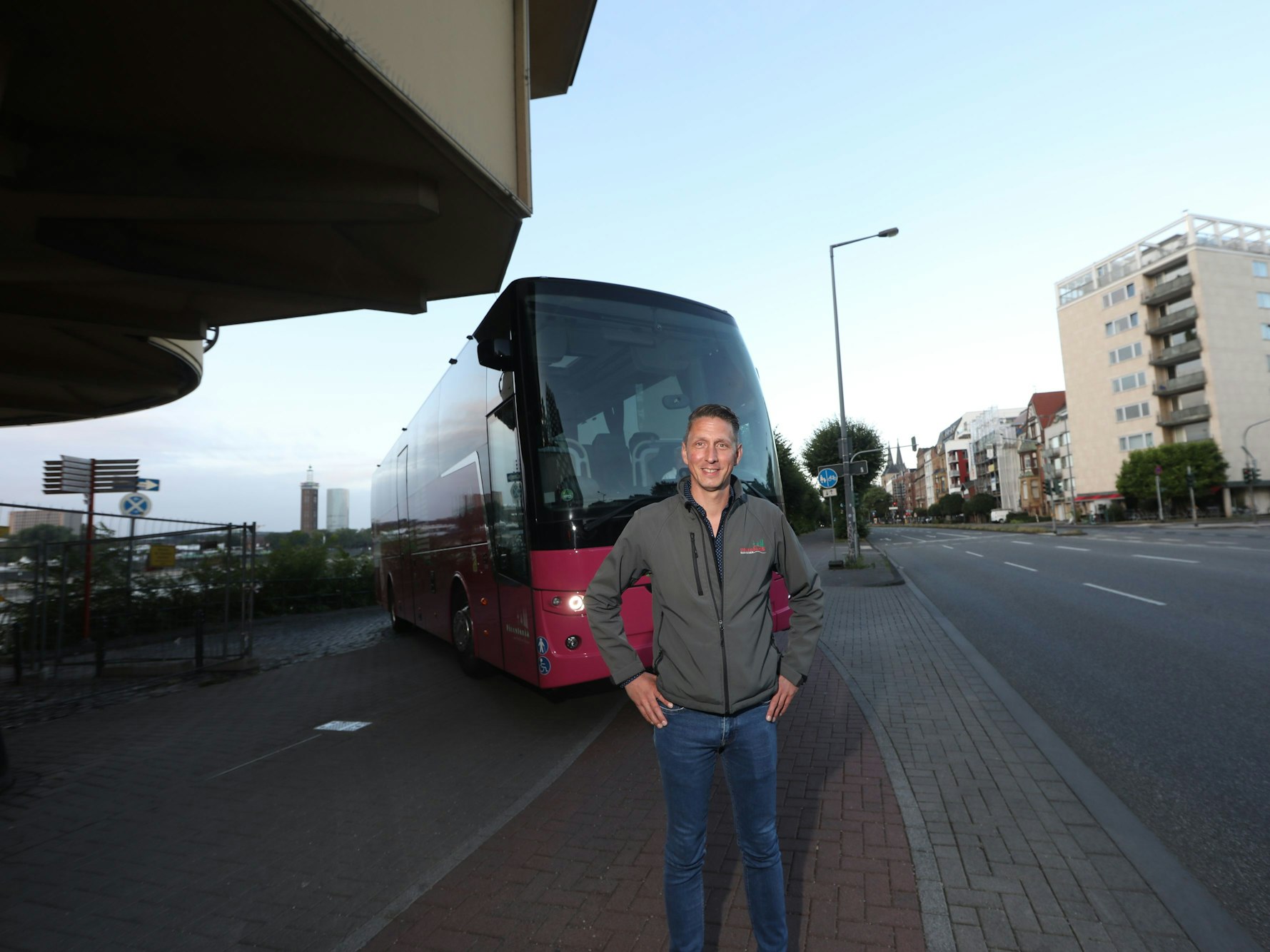 Markus Klein, Inhaber des Busunternehmens Piccolonia, wartet am Rheinufer auf den Reisebus, mit dem er demonstrieren will, dass die Zu- und Ausfahrt unproblematisch ist. Die Stadt behauptet das Gegenteil.