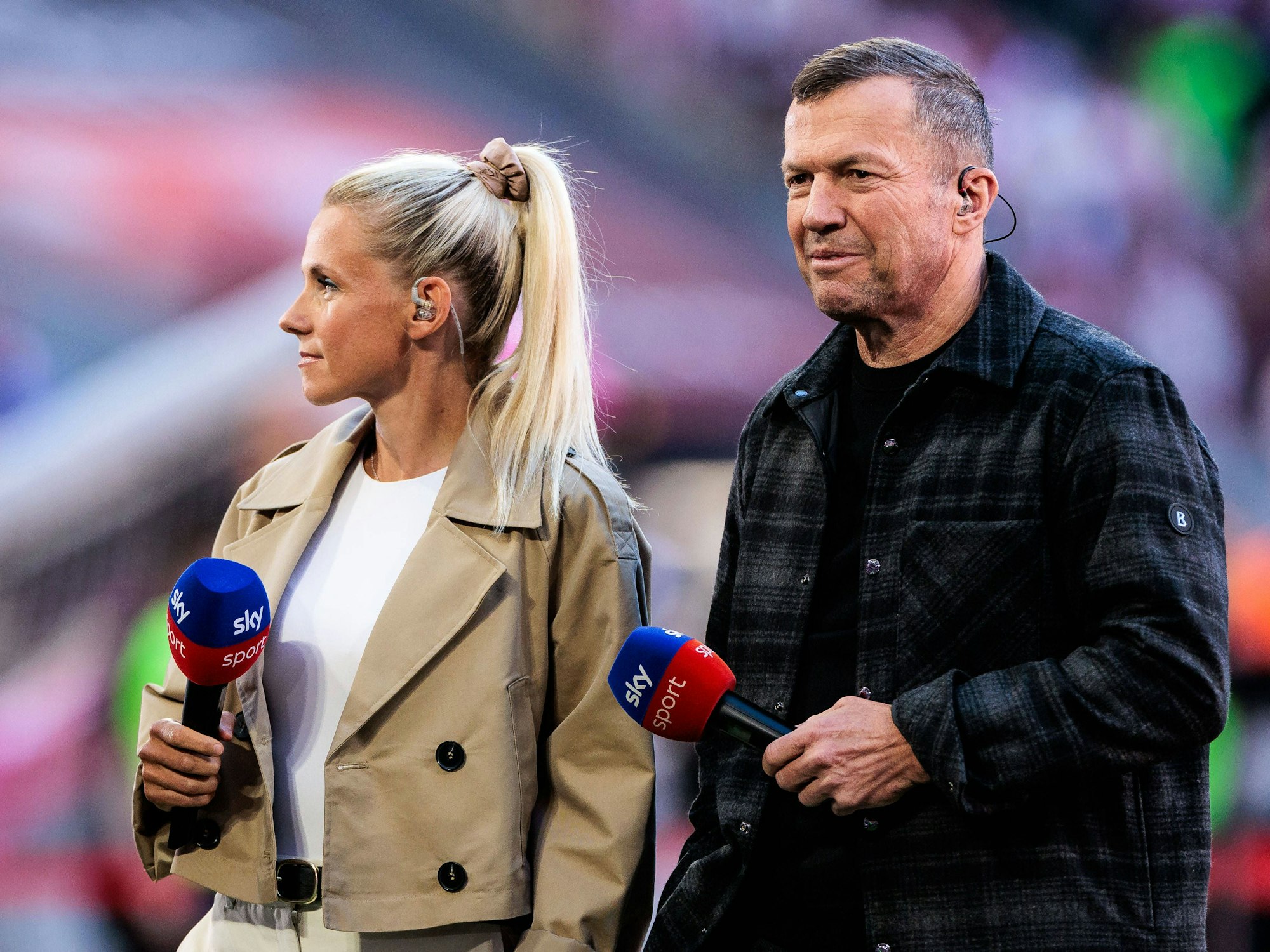 Lothar Matthäus und Julia Simic halten ein Sky-Mikrofon in der Hand.