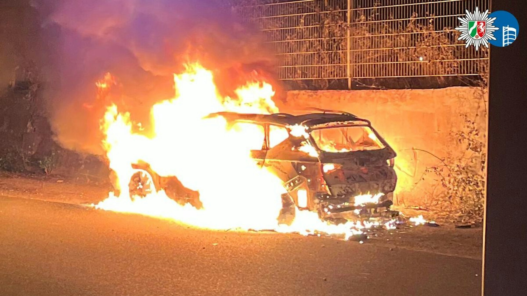 Ein ausgebranntes Auto am Straßenrand.