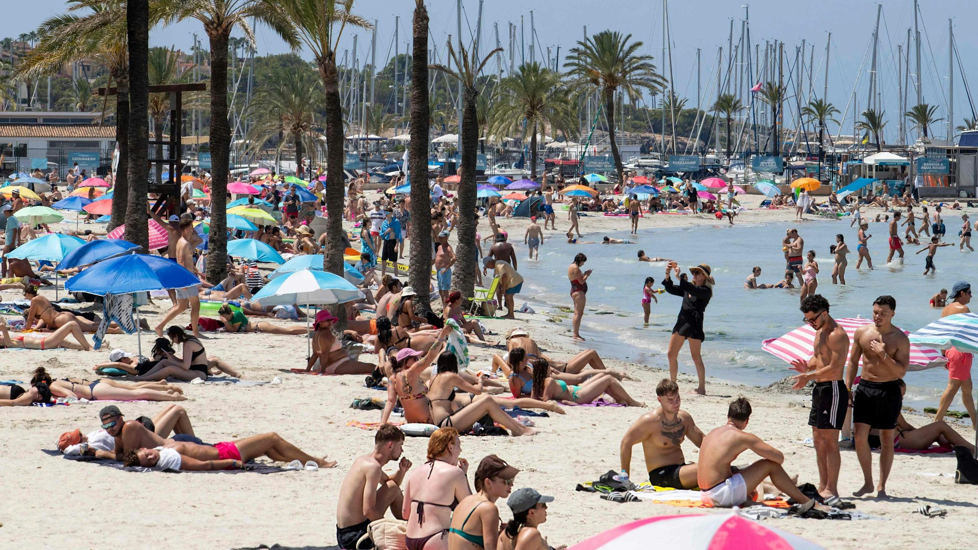 Urlauber und Urlauberinnen genießen die Sonne am Strand auf Mallorca. Die Polizei warnt vor illegalen Strand-Drinks.