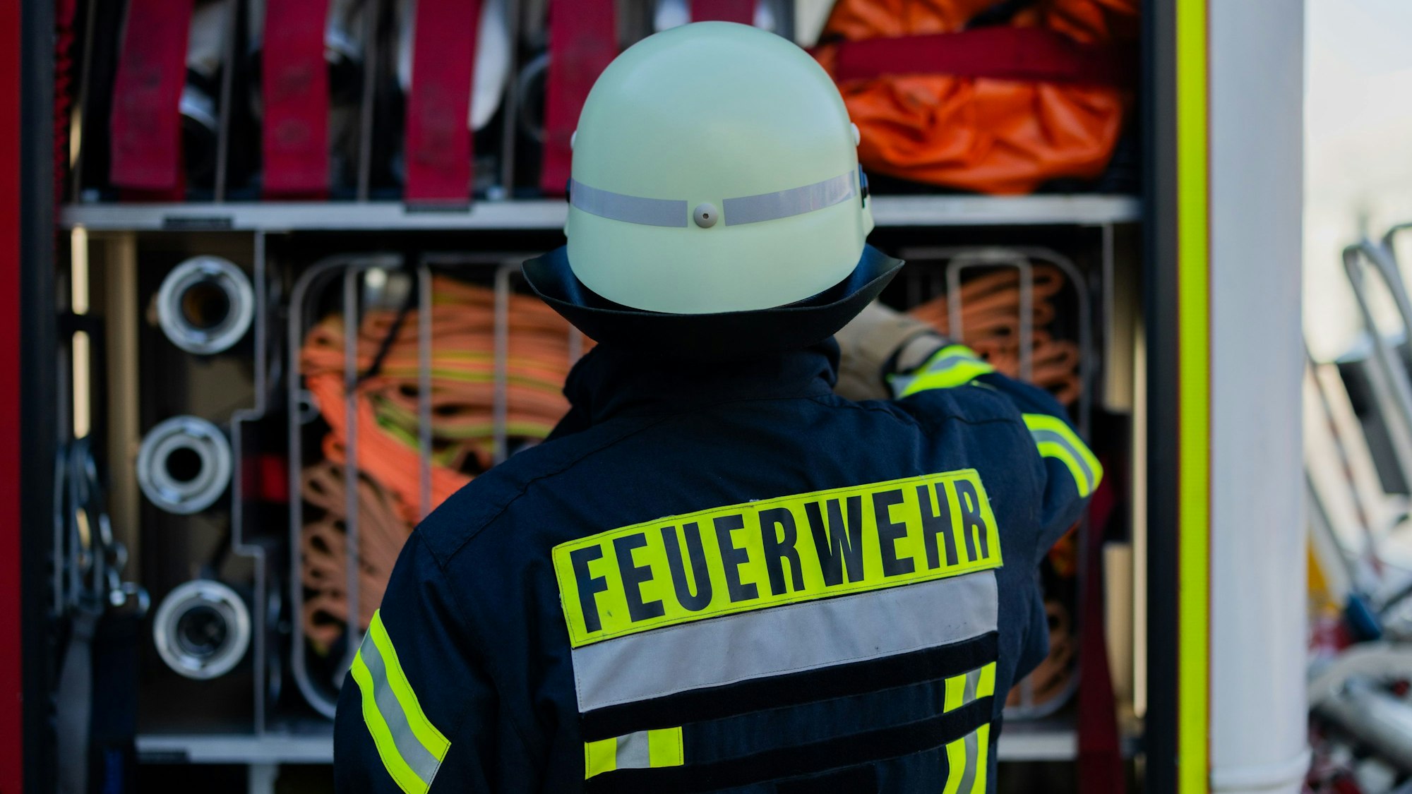 Ein Feuerwehrmann an einem Einsatzfahrzeug.