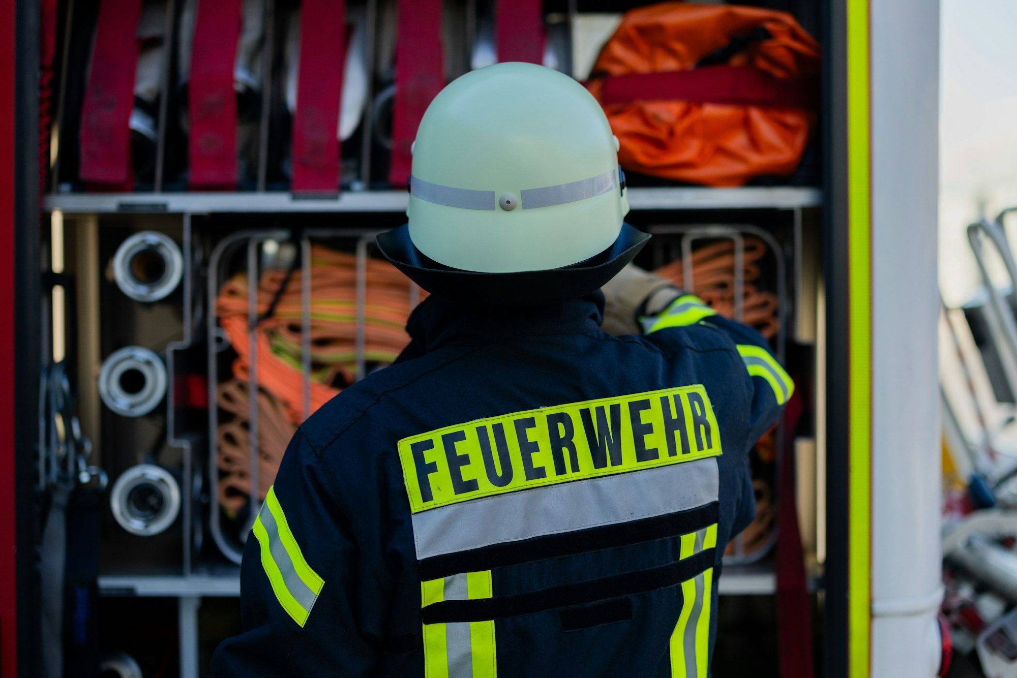 Ein Feuerwehrmann holt Equipment aus einem Einsatzfahrzeug an der Feuerwache der Feuerwehr.