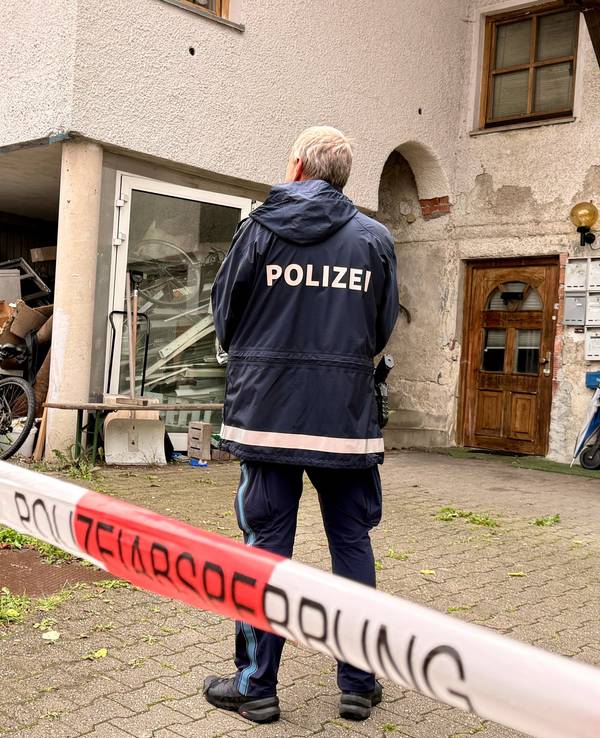 Ein Polizist steht hinter einer Absperrung vor einem Mehrfamilienhaus. In dem Haus im niederbayerischen Zwiesel sind drei Leichen gefunden worden. Man gehe derzeit von einem Tötungsdelikt aus, sagte eine Polizeisprecherin. Ein Verdächtiger sei in Österreich festgenommen worden.