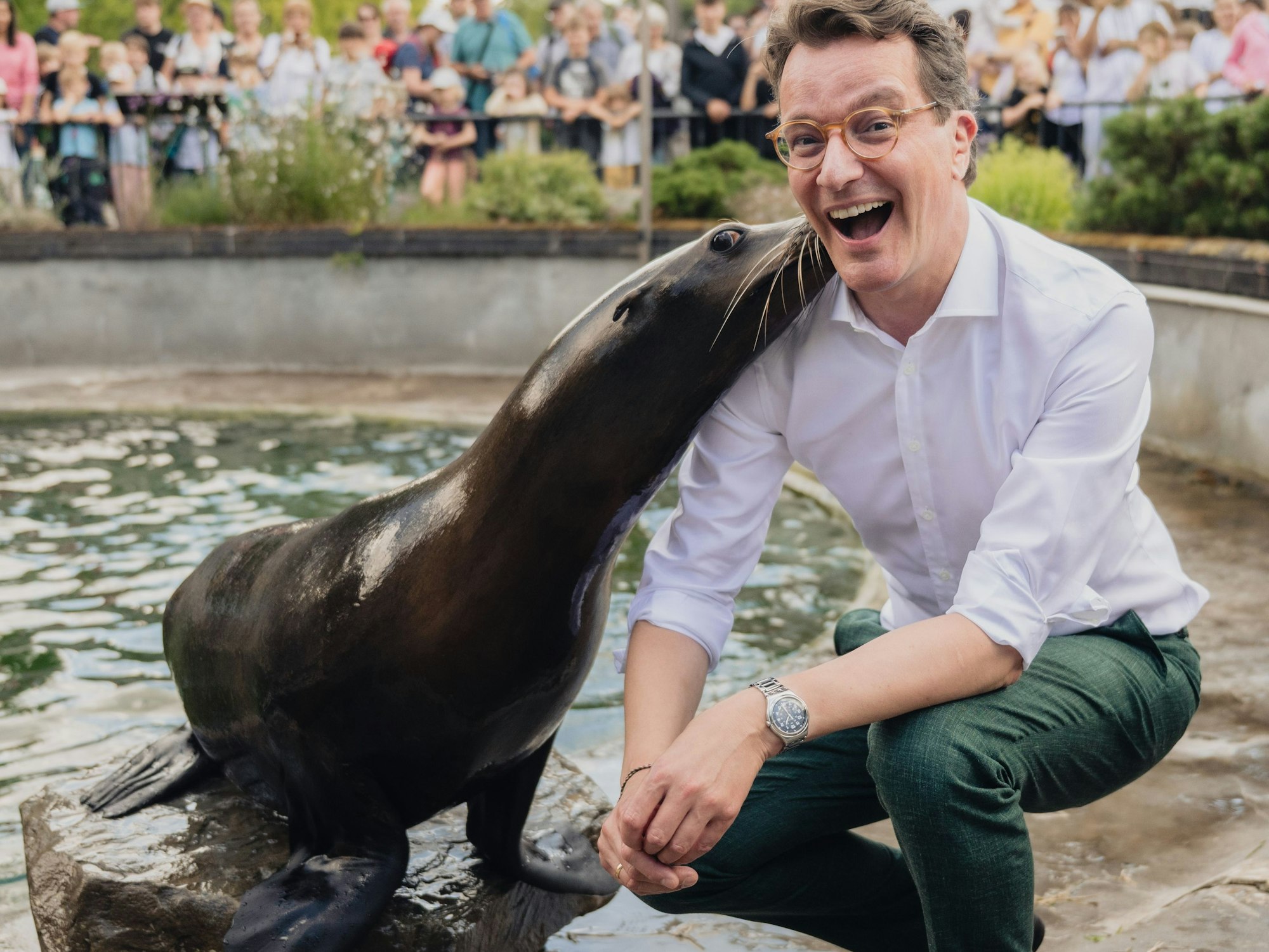 MP Hendrik Wüst bekommt von einer Robbe einen feuchten Kuss.