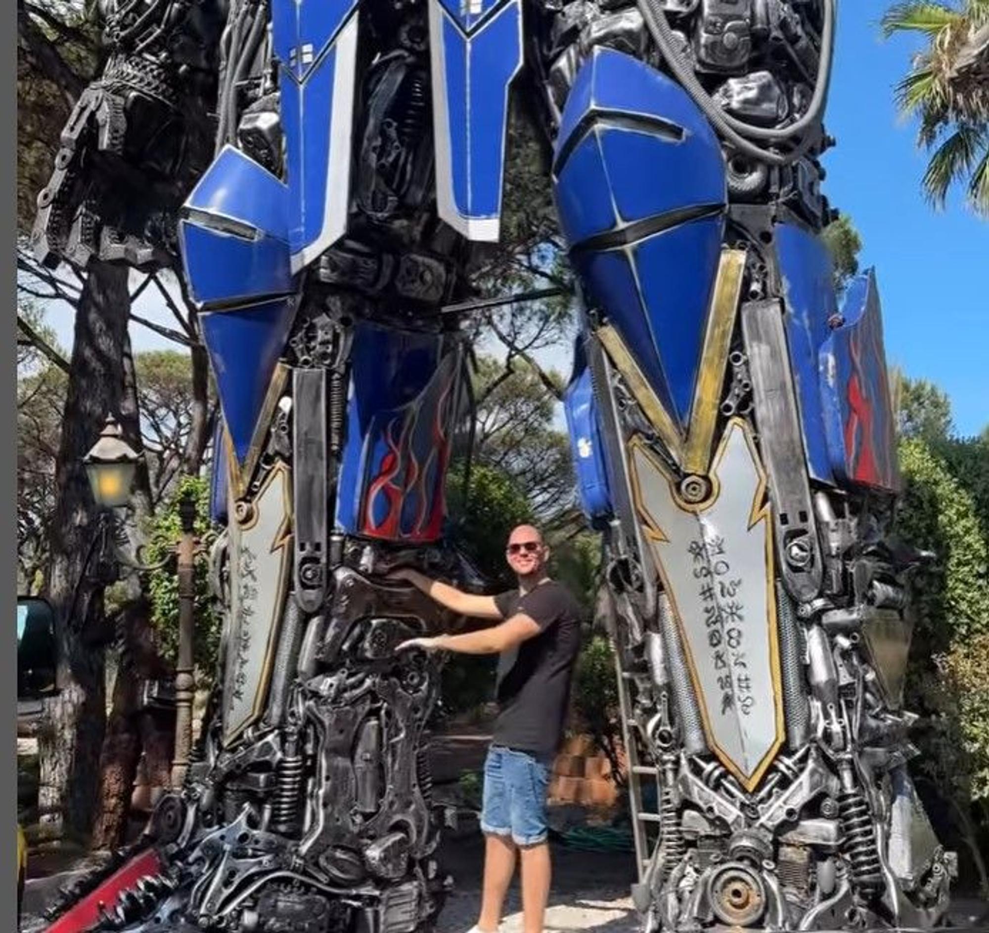 Ein Mitarbeiter der Geissens schraubt an einer überdimensionalen Transformer-Figur.