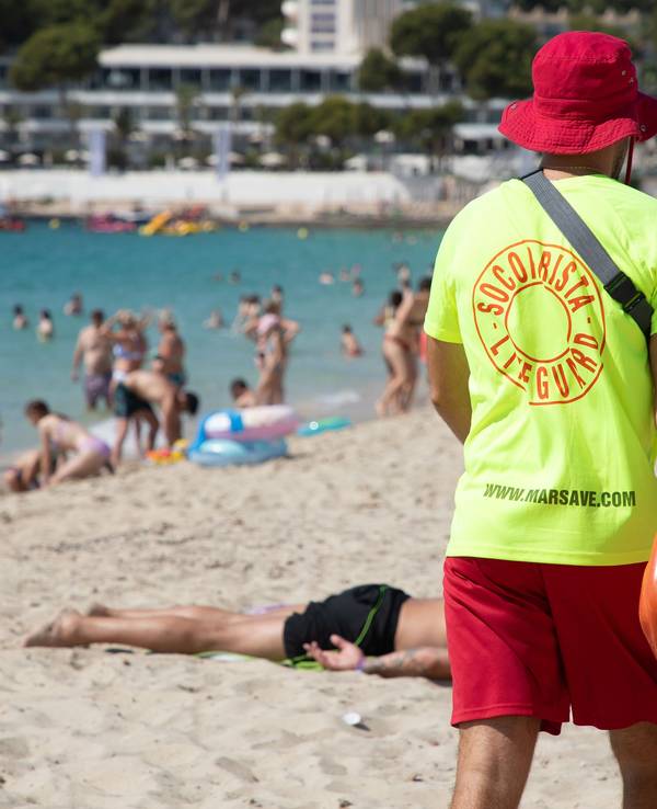 Ein Rettungsschwimmer geht am Strand von Magaluf auf Mallorca entlang.