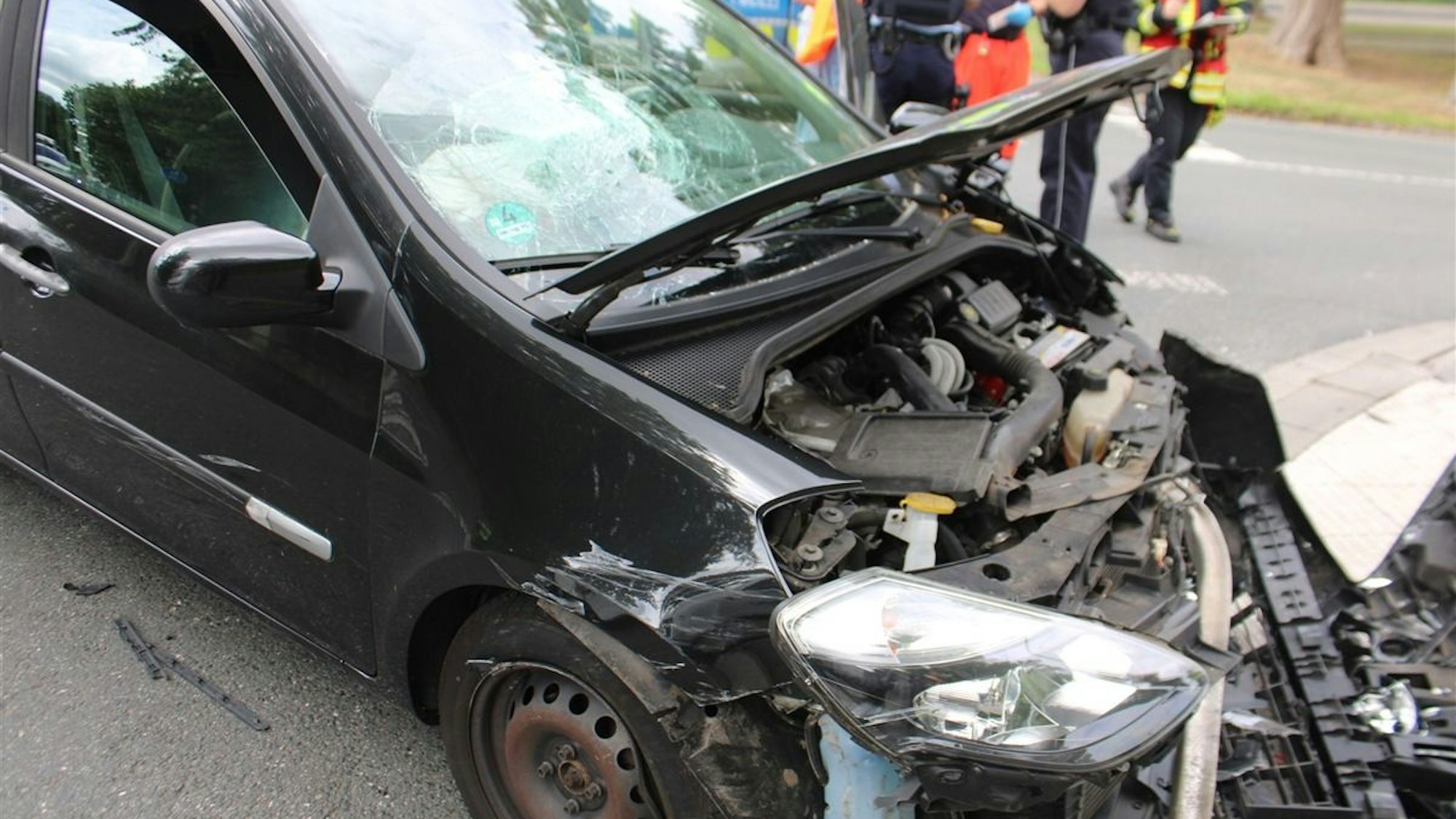 Drei bei einem Unfall beschädigte Autos stehen im Kreuzungsbereich.