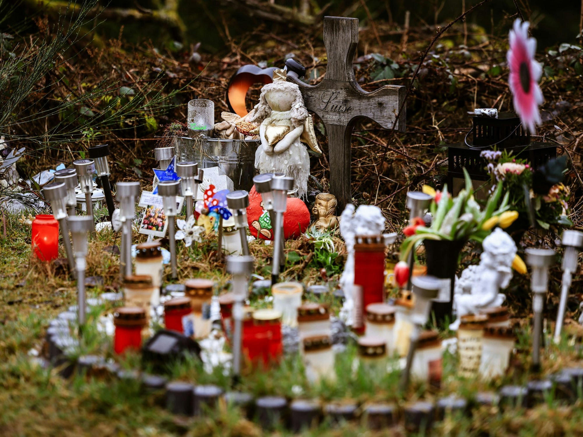 Kerzen, Blumen und Figuren liegen am Fundort von Luises Leiche an der Landesgrenze zwischen Rheinland-Pfalz und Nordrhein-Westfalen.