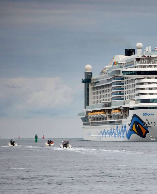 Das 300m lange Kreuzfahrtschiff AIDAprima passiert den Molenkopf der Hafeneinfahrt von Warnemünde.
