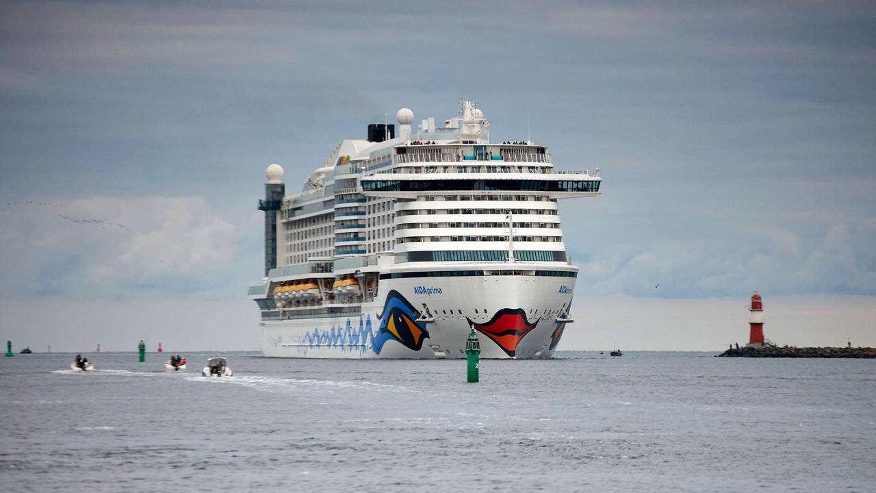 Das 300m lange Kreuzfahrtschiff AIDAprima passiert den Molenkopf der Hafeneinfahrt von Warnemünde.