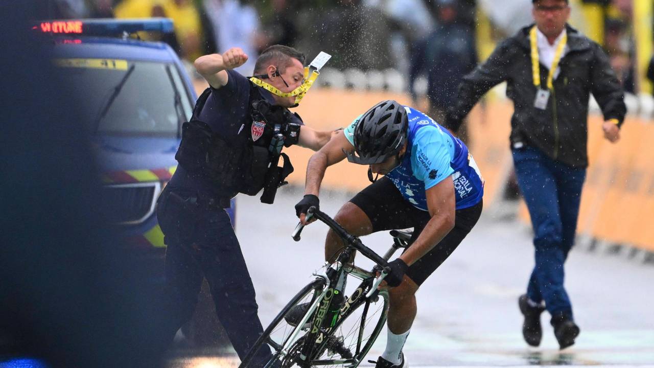 Ein Sicherheitsmann stößt einen Radfahrer im Ziel der Tour de France zu Boden.