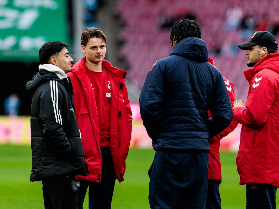 Jens Castrop unterhält sich mit mehreren FC-Profis.