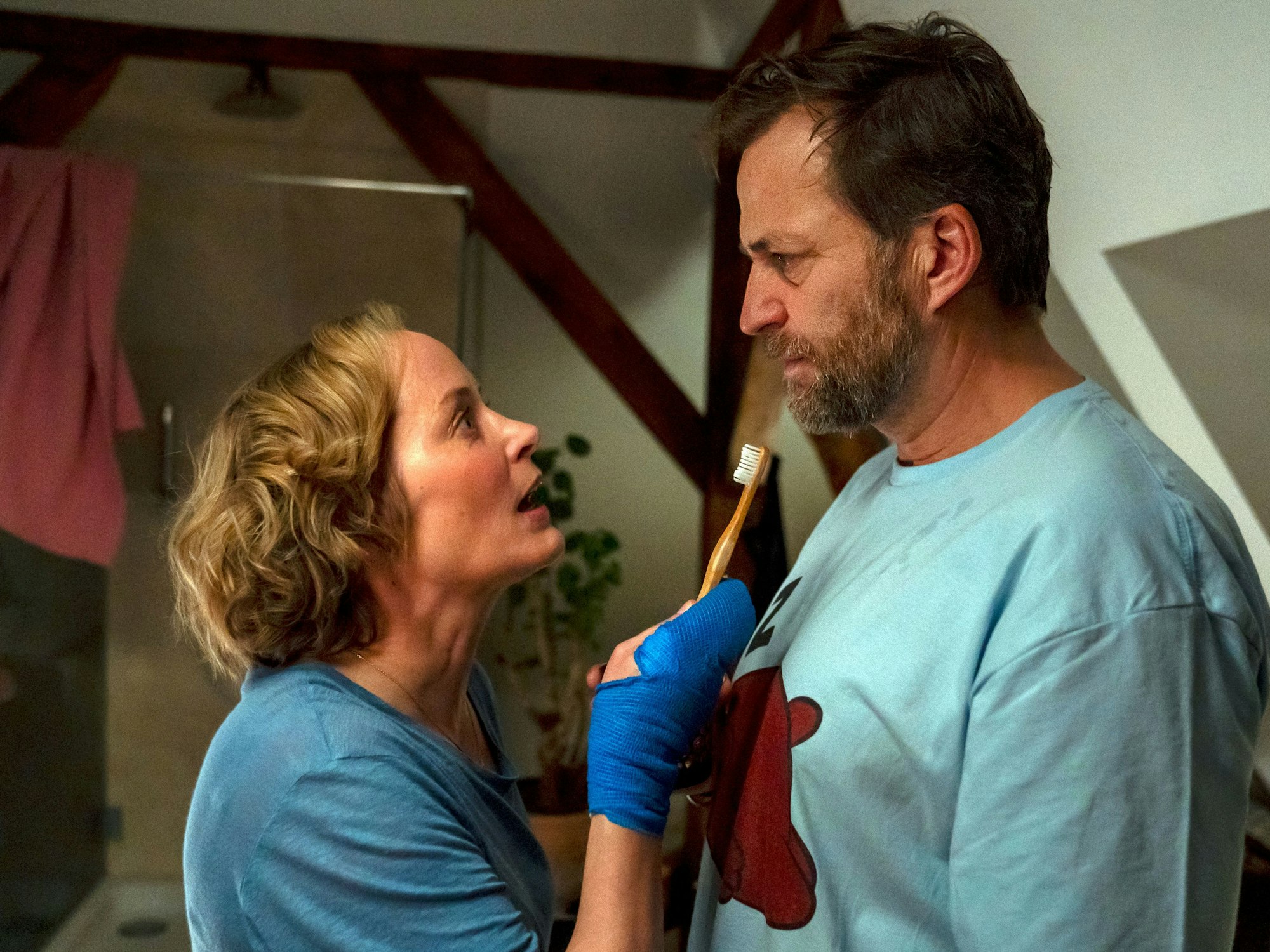 Eine Frau redet mit einer Zahnbürste in der Hand auf einen Mann ein.