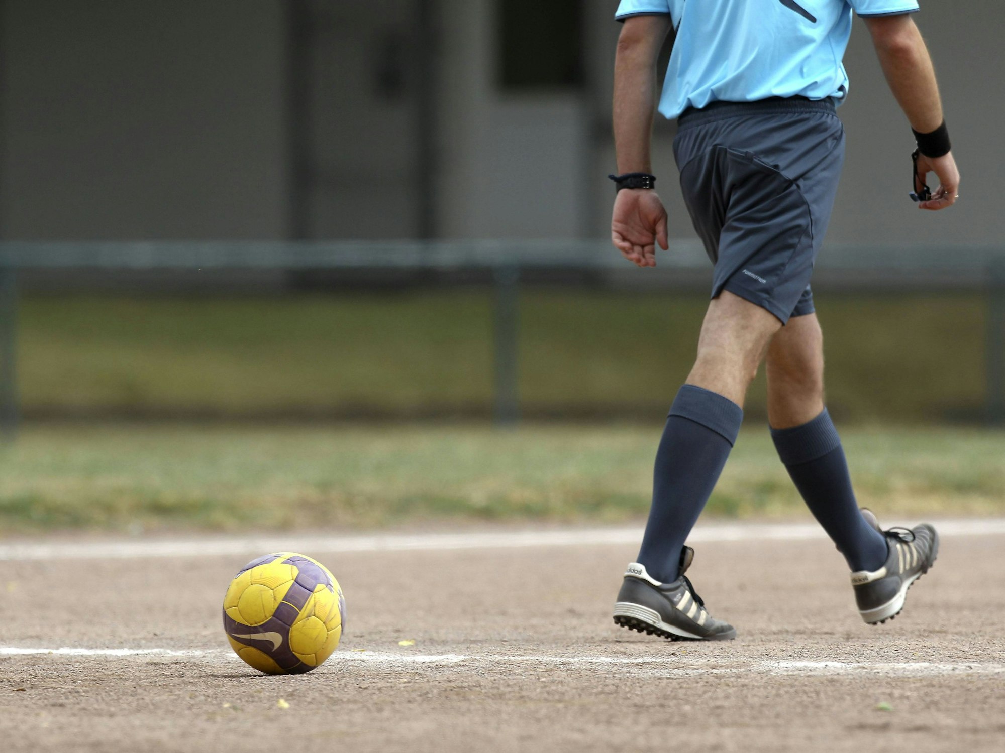 Ein Schiedsrichter auf einem Aschenplatz.