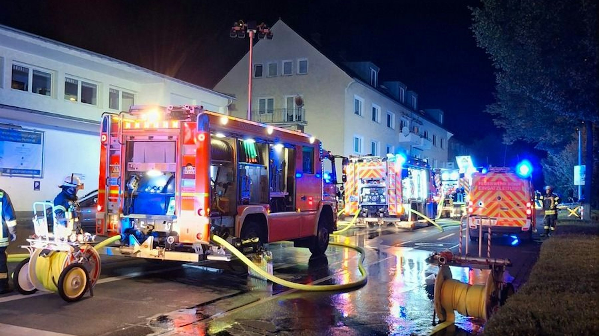 Feuerwehrautos vor einem brennenden Gebäude in Bonn-Plittersdorf.