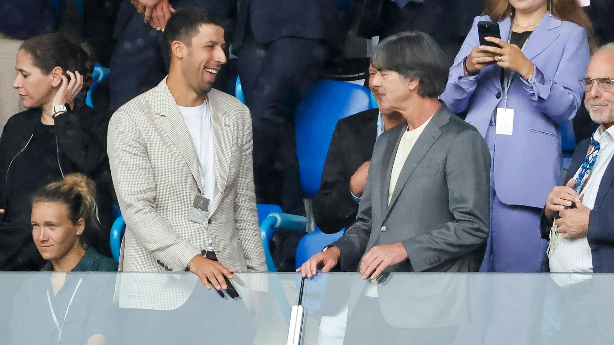 Sami Khedira unterhält sich mit Joachim Löw, daneben sitzt Josephine Henning.