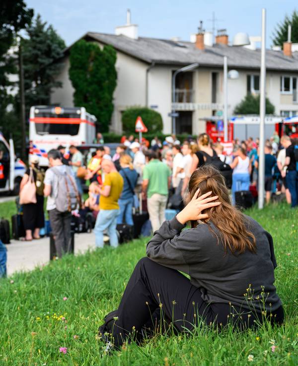 Zahlreiche Menschen stehen an einem Sammelplatz.
