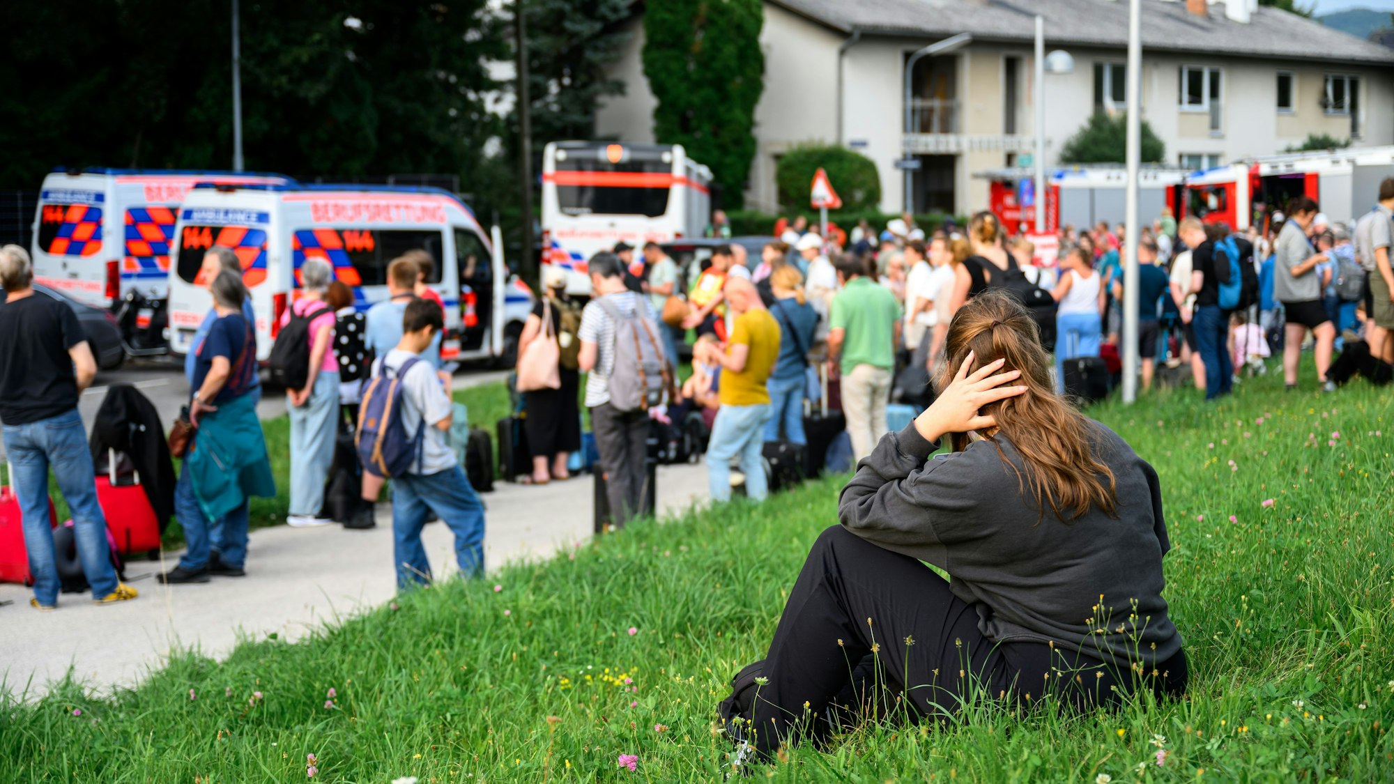 Zahlreiche Menschen stehen an einem Sammelplatz.