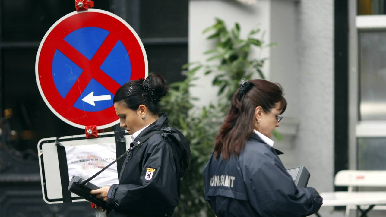 Zwei Politessen schreiben in Berlin die Kennzeichen von Autos auf, die im absoluten Halteverbot stehen.