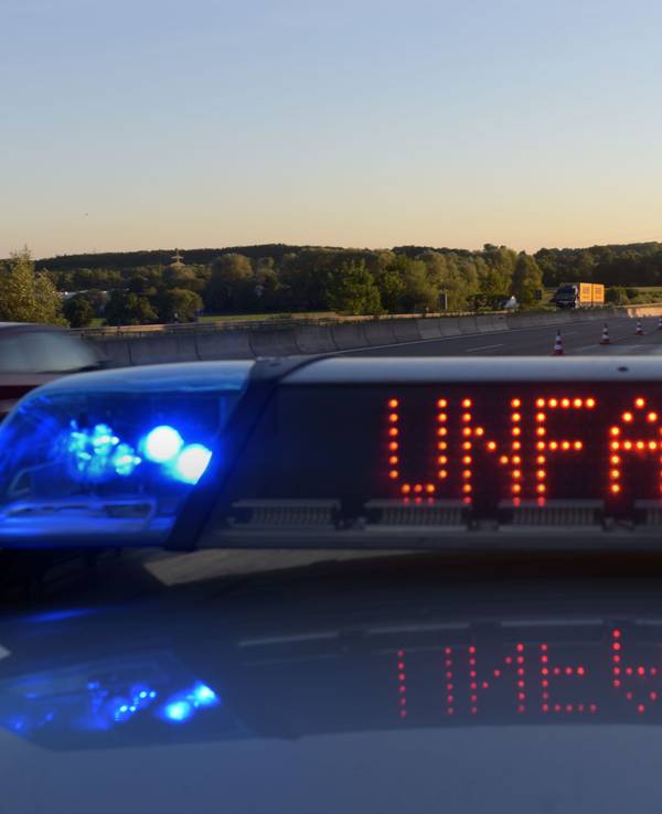 Ein Polizeifahrzeug warnt auf der Autobahn mit eine Leuchtschrift vor einer Unfallstelle.